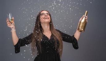 belle femme célébrant le nouvel an avec des confettis et du champagne photo