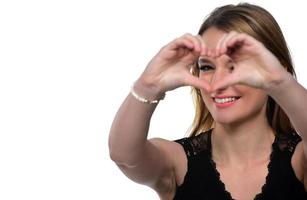 portrait d'une jeune femme faisant un geste de coeur avec ses mains photo