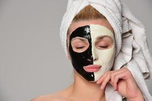 beau modèle féminin avec masque cosmétique facial noir et blanc photo