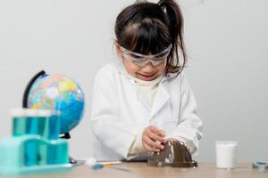 concept d'éducation, de science, de chimie et d'enfants - enfants ou étudiants avec expérience de fabrication de tubes à essai au laboratoire de l'école photo