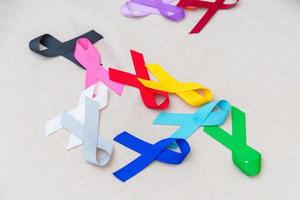 journée mondiale du cancer, 4 février. rubans colorés pour soutenir les personnes vivant et malades. soins de santé, combats, journée médicale et nationale de survie au cancer, concept de journée de sensibilisation à l'autisme photo