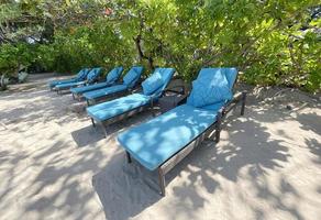 chaises longues ou chaises de plage sur la plage de sable blanc lors d'une chaude journée d'été dans un hôtel tropical de luxe photo