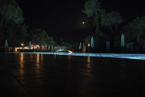 vue sur la piscine illuminée la nuit dans la station touristique photo