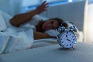 femme allongée dans son lit souffrant d'insomnie, sans sommeil et désespérée belle femme caucasienne éveillée la nuit incapable de dormir, se sentant frustrée et inquiète souffrant d'insomnie dans les troubles du sommeil photo