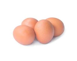 Quatre egss de poulet brun frais en pile ou en tas isolé sur fond blanc avec un tracé de détourage photo