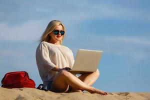 une femme indépendante travaille sur un ordinateur portable dans le désert photo