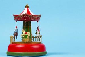 carrousel de jouets vintage sur fond bleu. carillon rouge avec carrousel, carrousel rétro photo