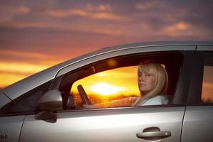 femme d'âge moyen conduisant une voiture contre le ciel coucher de soleil.étranger photo