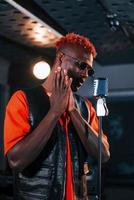 avoir une pratique vocale. jeune artiste afro-américain répétant dans un studio d'enregistrement photo