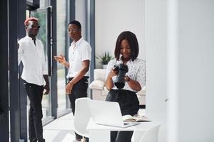 femme testant la caméra. groupe de gens d'affaires afro-américains travaillant ensemble au bureau photo