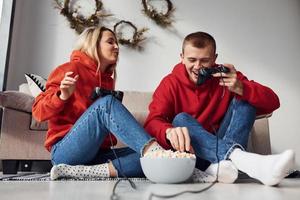 jeune couple charmant ensemble à la maison jouant à des jeux vidéo le week-end et les vacances ensemble photo