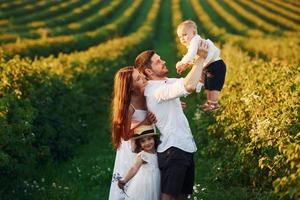 père, mère avec fille et fils passant du temps libre à l'extérieur aux beaux jours de l'été photo