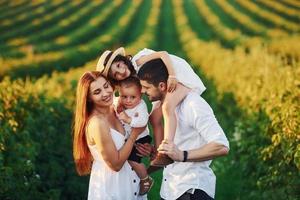 au champ agricole. père, mère avec fille et fils passant du temps libre à l'extérieur aux beaux jours de l'été photo