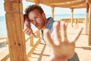 jeune homme européen passe des vacances et profite de temps libre sur la plage de la mer photo