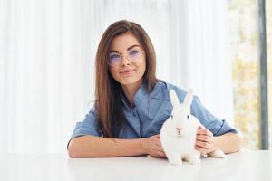 la vétérinaire féminine est à l'intérieur avec un petit lapin. conception des soins de santé photo