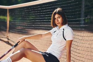 vue de côté. La joueuse de tennis est sur le terrain pendant la journée photo