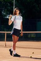 debout et posant. La joueuse de tennis est sur le terrain pendant la journée photo