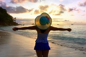 fille heureuse sur la plage au lever du soleil photo