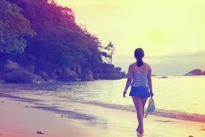 fille touristique marchant sur la plage style vintage photo
