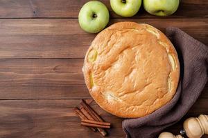 tarte aux pommes charlotte sur table en bois avec pomme fraîche et cannelle , vue d'en haut photo