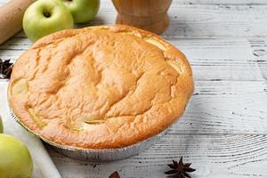 tarte aux pommes charlotte sur table en bois blanc avec pomme fraîche et cannelle photo