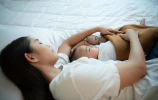 une mère doit dormir et se reposer avec son nouveau-né. dans la chambre blanche, la chaleur du soleil le soir de la journée. photo