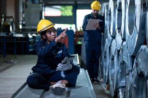 jeune ingénieure apprenant à faire fonctionner des machines dans une usine avec des ingénieurs chevronnés photo