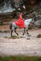rochers dovbush et équitation, une femme à cheval dans une robe rouge pieds nus. photo