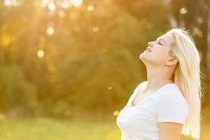 femme heureuse libre profitant de la nature. fille de beauté en plein air. notion de liberté. fille de beauté sur le ciel et le soleil. rayons de soleil. jouissance photo