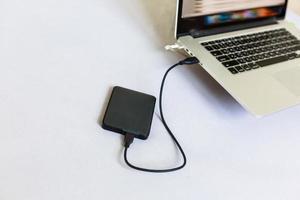 disque dur externe noir se connectant à un ordinateur portable photo