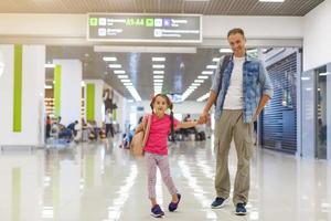 père et petite fille marchant dans l'aéroport, voyage en famille photo