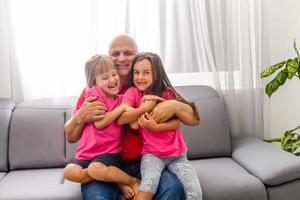 homme mûr jouant avec ses petites-filles à la maison. photo