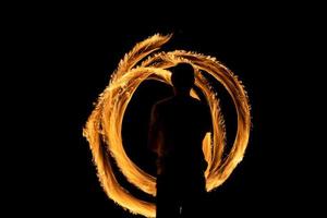 une belle photo d'une personne faisant un spectacle de poi de feu dans le noir