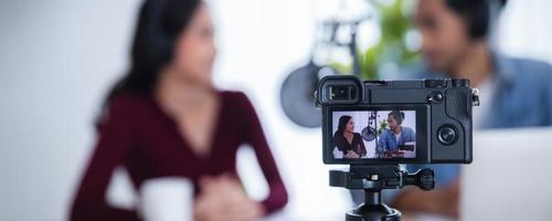 caméra en gros plan enregistrant un podcasteur féminin et masculin asiatique faisant un podcast audio dans un concept de home studio, dj et radio en ligne photo
