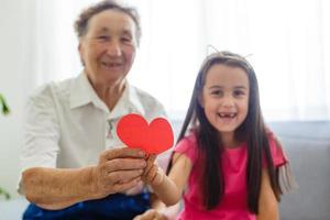 senior tricotant avec sa petite-fille à la maison photo