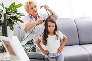 grand-mère fait friser les cheveux petite-fille photo