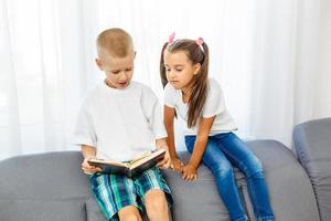 les enfants lisent un livre à la maison photo