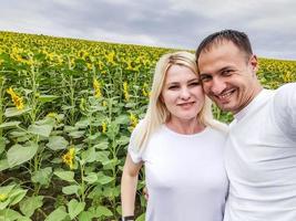 nature d'automne. jeune couple romantique marchant dans un champ de tournesols au coucher du soleil photo