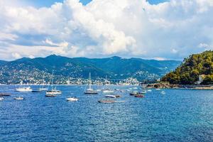 bateaux de pêche amarrés sur l'eau dans le port de la mer ligurienne et méditerranéenne près du littoral de la riviera di levante du parc national de la côte des cinque terre avec ciel bleu, village de riomaggiore, ligurie, italie. photo