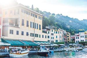 bateaux de pêche amarrés sur l'eau dans le port de la mer ligurienne et méditerranéenne près du littoral de la riviera di levante du parc national de la côte des cinque terre avec ciel bleu, village de riomaggiore, ligurie, italie. photo