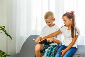 les enfants lisent un livre à la maison photo