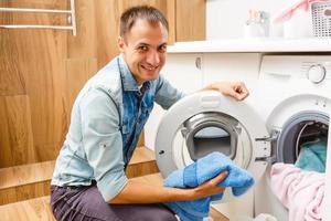 jeune entrepreneur réparant une machine à laver dans la cuisine photo