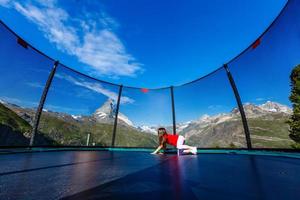 petite fille sur un trampoline dans les montagnes, alpes photo