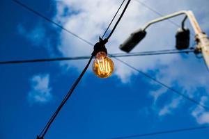 gros plan d'un filament de style edison sur une ampoule contre un ciel nuageux. crise de l'énergie. photo