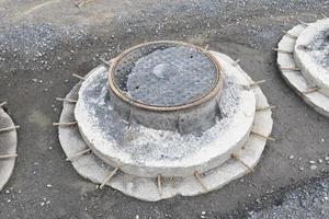 Couvercle de trou d'homme sur le sentier de la zone de construction d'égouts photo