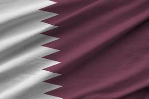 drapeau du qatar avec de grands plis agitant de près sous la lumière du studio à l'intérieur. les symboles et couleurs officiels de la bannière photo