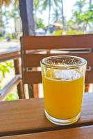 verre de jus d'orange sur table en bois puerto escondido mexique. photo