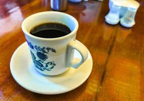 pot de tasse blanc bleu avec table basse en bois noir mexique. photo