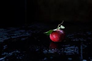 pomme rouge sur fond noir. gouttes d'eau . photo