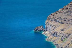 haute vue sur les falaises volcaniques, les baies, la mer bleue claire. paysage naturel, couleurs calmes photo